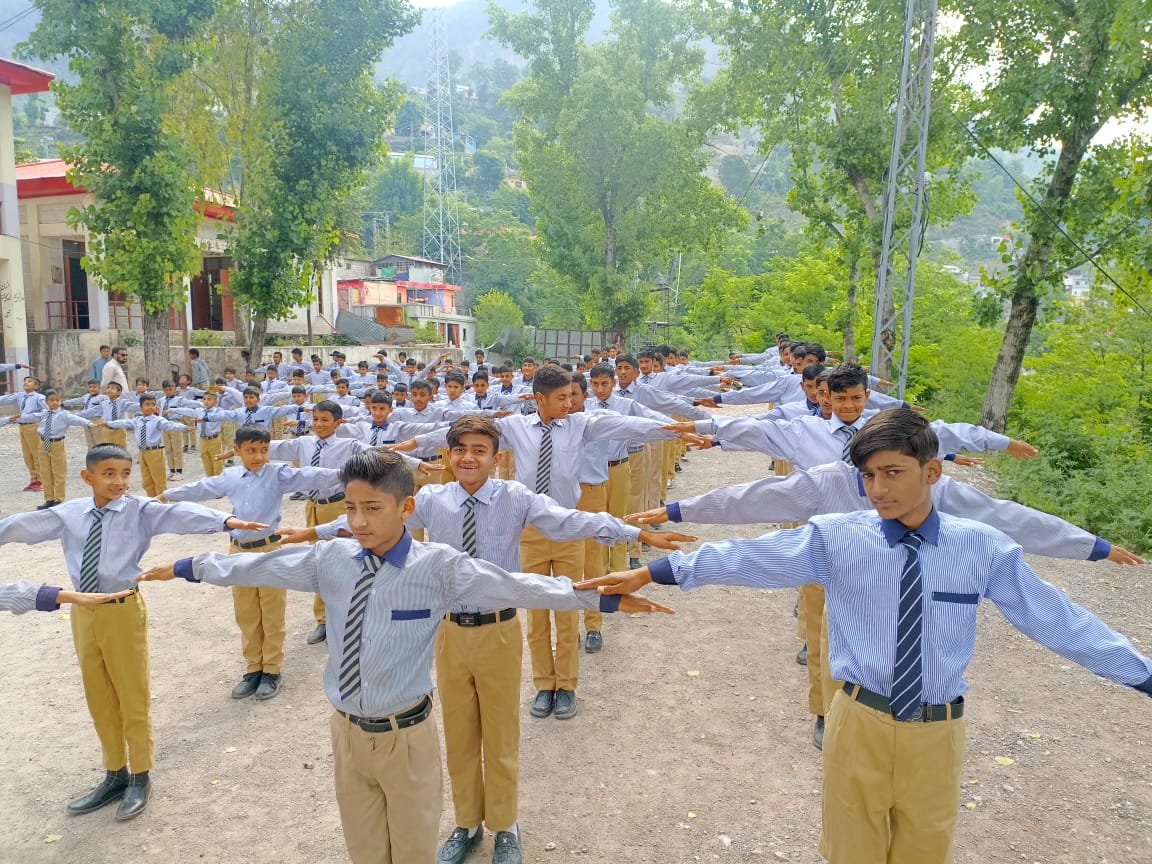 Students doing PT exercise with arms outstretched